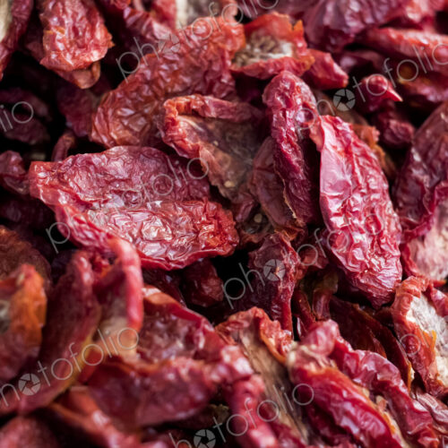 High angle close up of dried red tomatoes at a market stall. High angle close up of dried red tomatoes at a market stall.