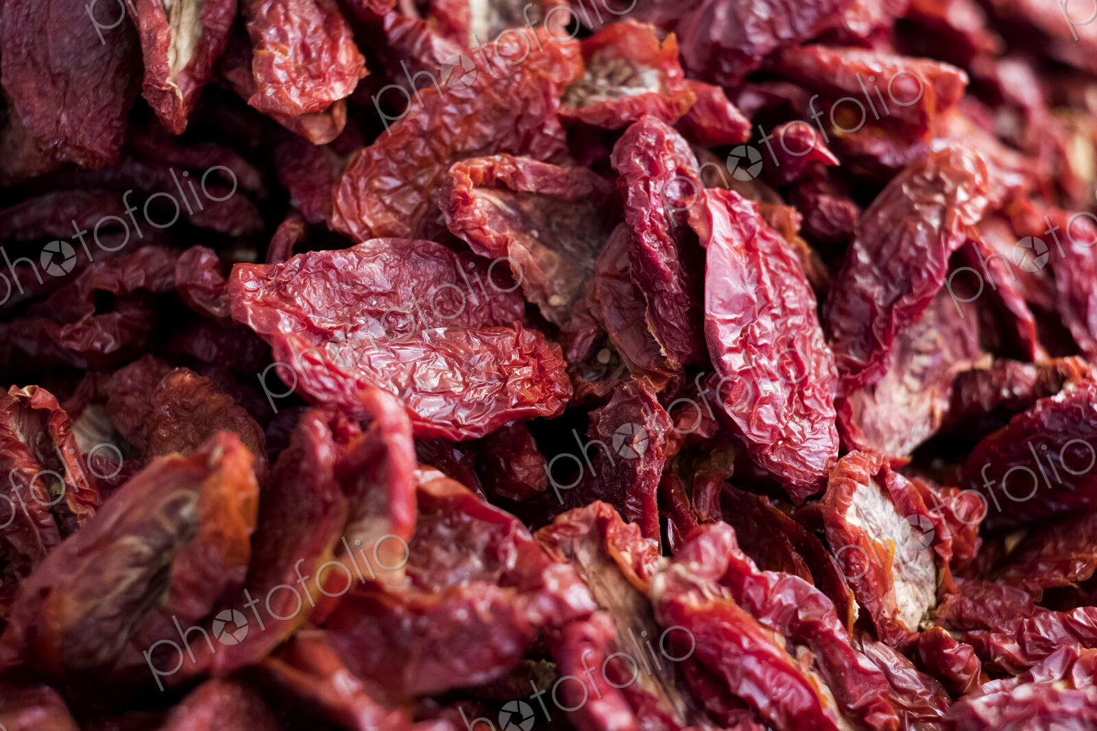 High angle close up of dried red tomatoes at a market stall.