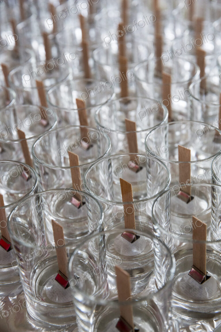 High angle close up of empty glass jars with wooden wicks, for candle making.