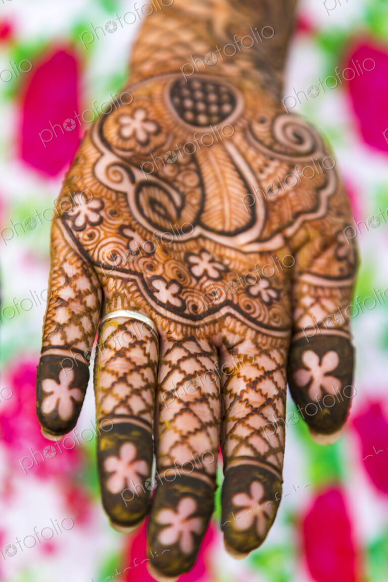 High angle close up of female hand covered in Henna tattoos with intricate geometric,…
