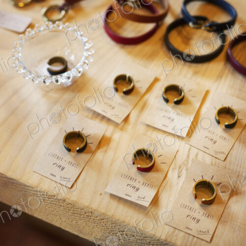 High angle close up of finger rings and leather bracelets on a table in a leather shop. High angle close up of finger rings and leather bracelets on a table in a leather shop.