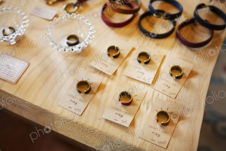 High angle close up of finger rings and leather bracelets on a table in a leather shop.