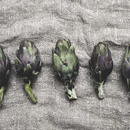 High angle close up of fresh artichokes on a grey background