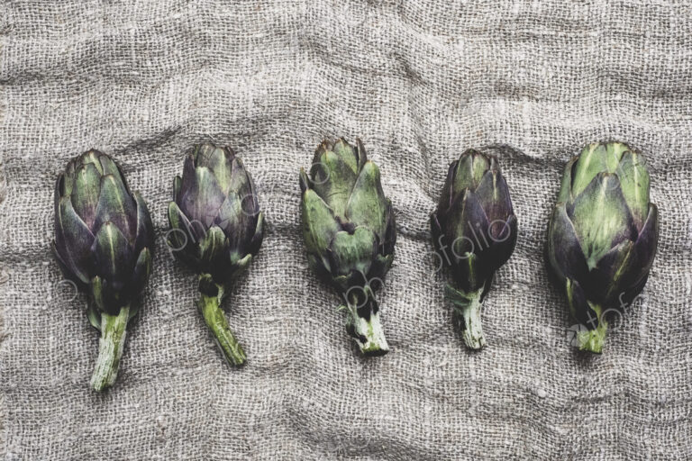 High angle close up of fresh artichokes on a grey background