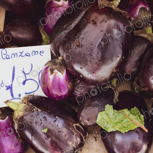 High angle close up of fresh purple aubergines at an Italian market stall. High angle close up of fresh purple aubergines at an Italian market stall.