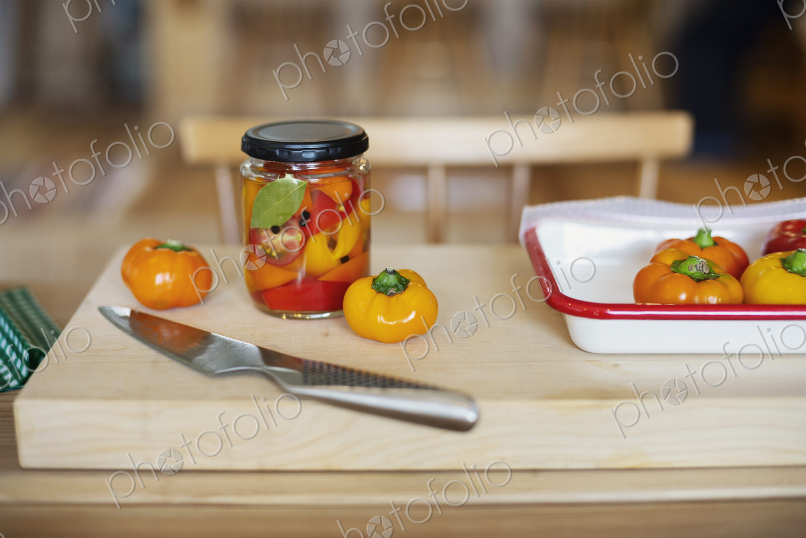 High angle close up of fresh vegetables and knife on wooden cutting board.