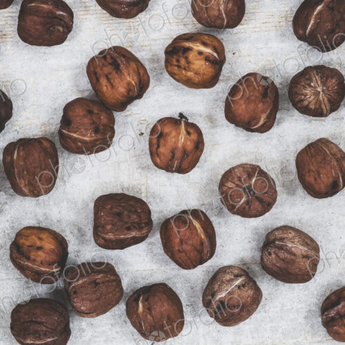 High angle close up of fresh walnuts on grey background. High angle close up of fresh walnuts on grey background.