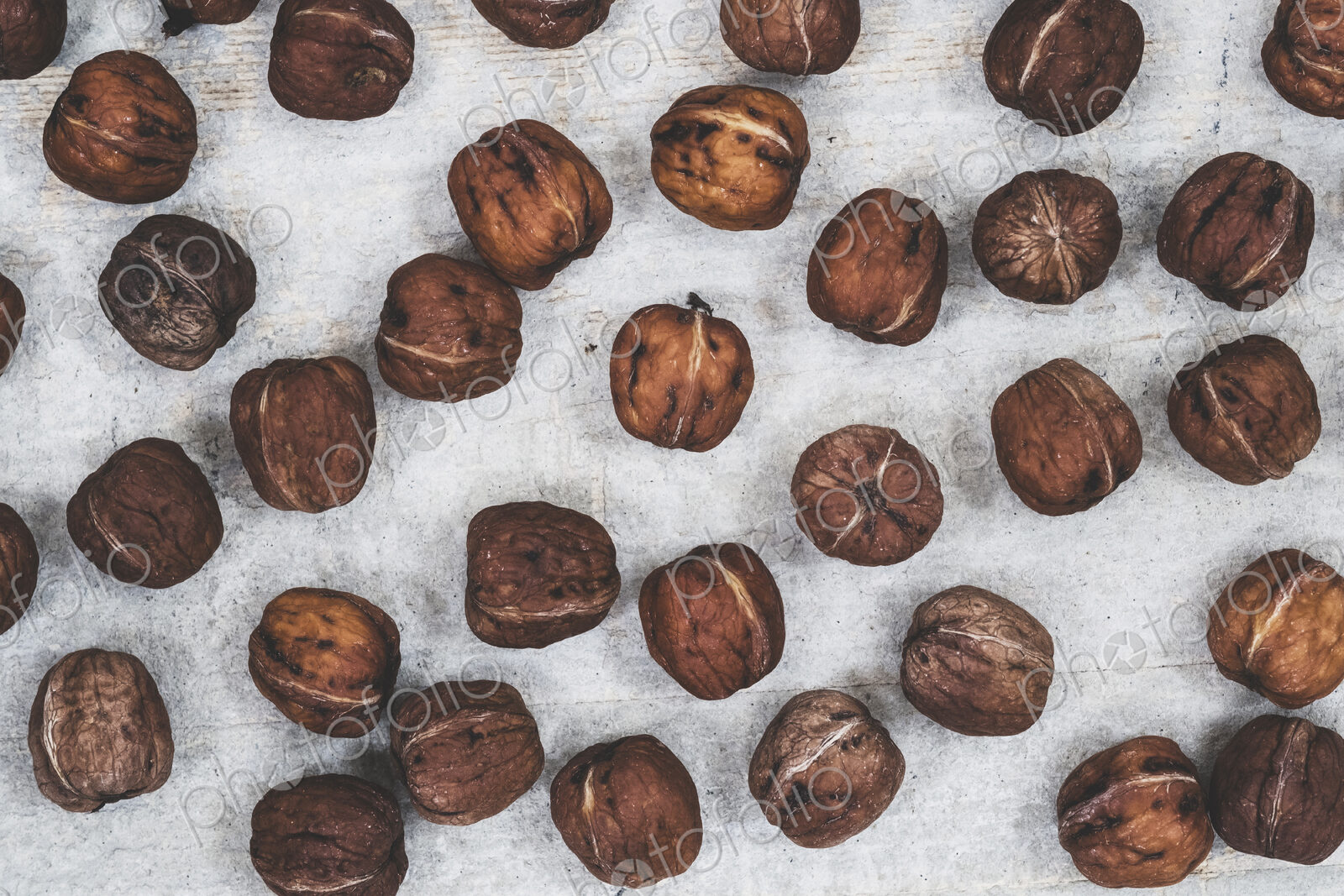 High angle close up of fresh walnuts on grey background.