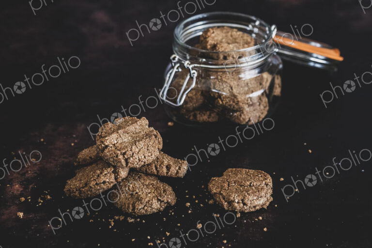 High angle close up of freshly baked chocolate cookies in a glass jar.