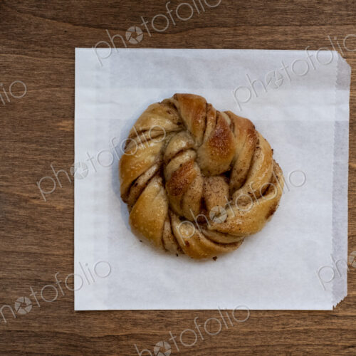High angle close up of freshly baked cinnamon bun in an artisan bakery.