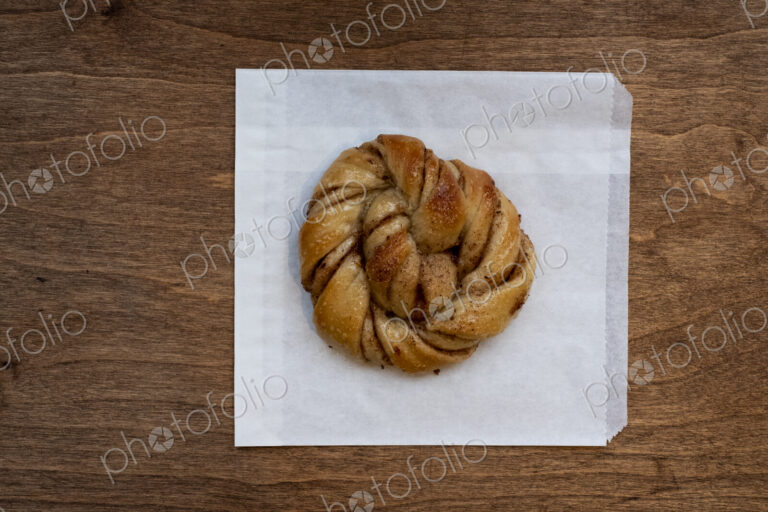 High angle close up of freshly baked cinnamon bun in an artisan bakery.