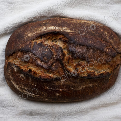 High angle close up of freshly baked loaf of bread in an artisan bakery.