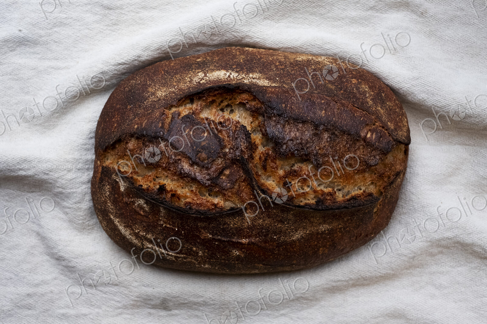 High angle close up of freshly baked loaf of bread in an artisan bakery.