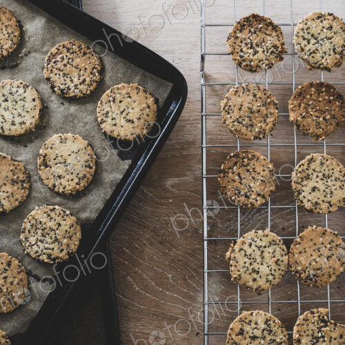 High angle close up of freshly baked seeded crackers on a baking tray. High angle close up of freshly baked seeded crackers on a baking tray.