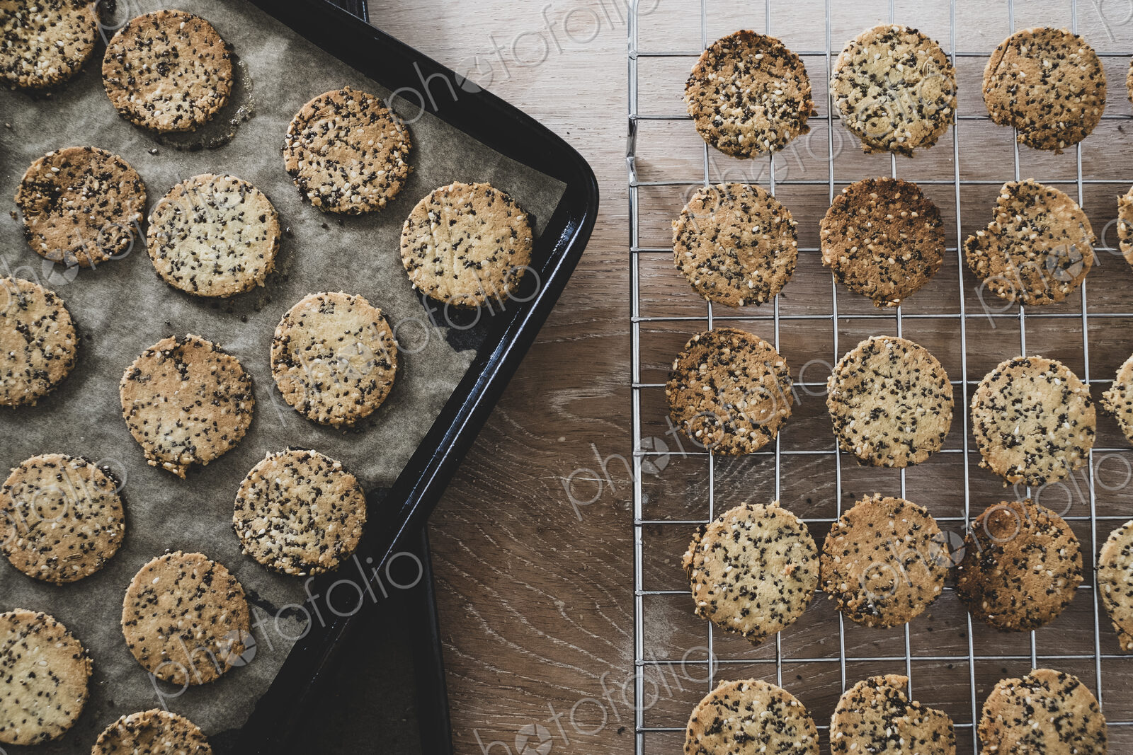 High angle close up of freshly baked seeded crackers on a baking tray.