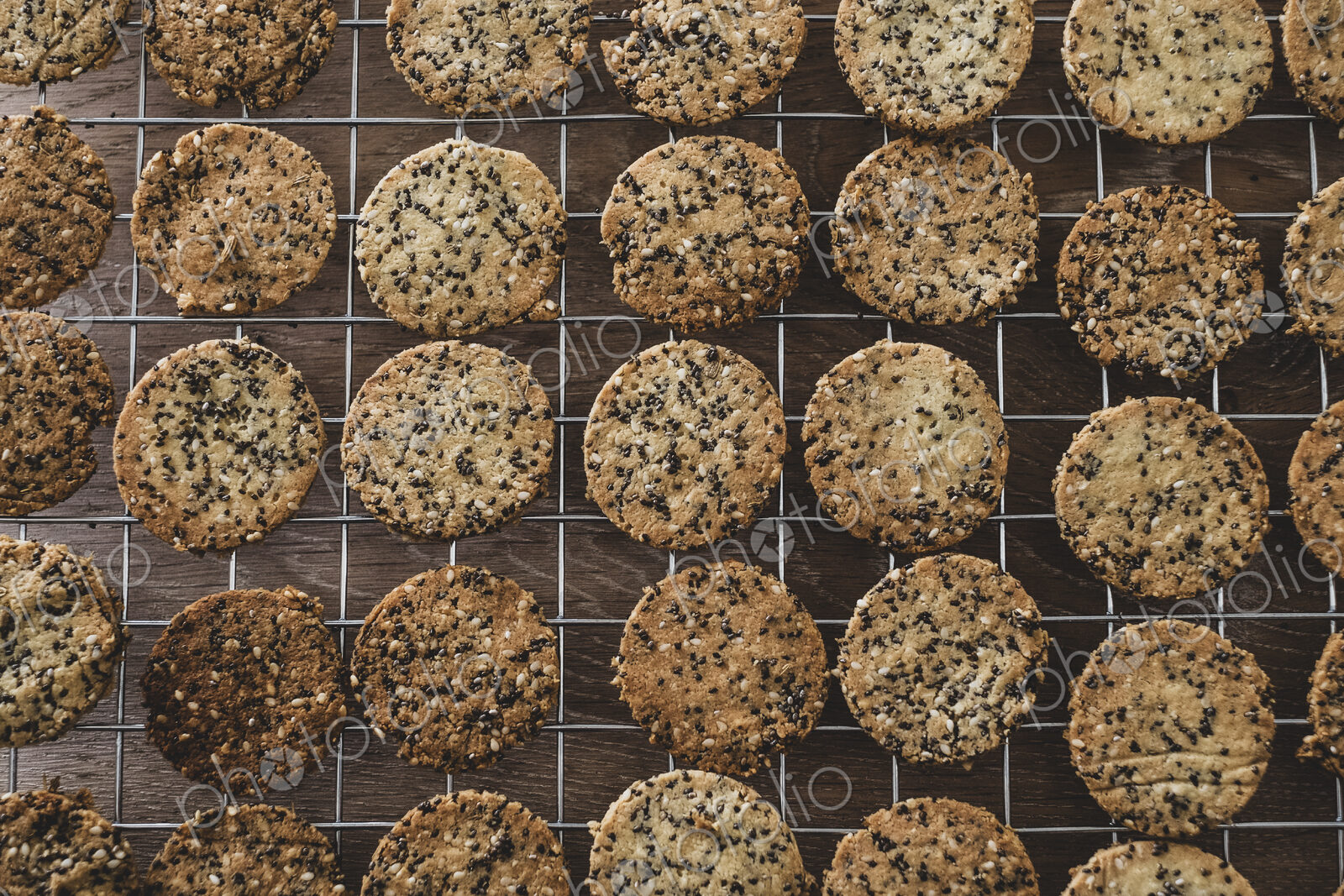 High angle close up of freshly baked seeded crackers on a baking tray.