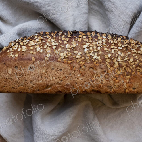 High angle close up of freshly baked seeded loaf of bread in an artisan bakery.