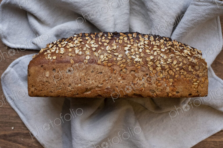 High angle close up of freshly baked seeded loaf of bread in an artisan bakery.