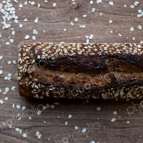 High angle close up of freshly baked seeded loaf of bread in an artisan bakery.