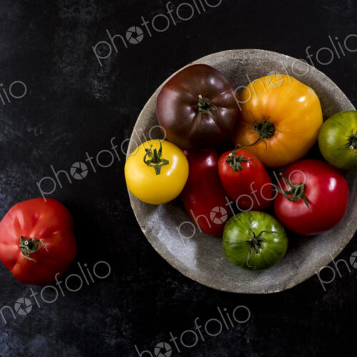 High angle close up of grey plate with selection of tomatoes in various shapes and… High angle close up of grey plate with selection of tomatoes in various shapes and…