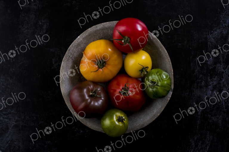 High angle close up of grey plate with selection of tomatoes in various shapes and…