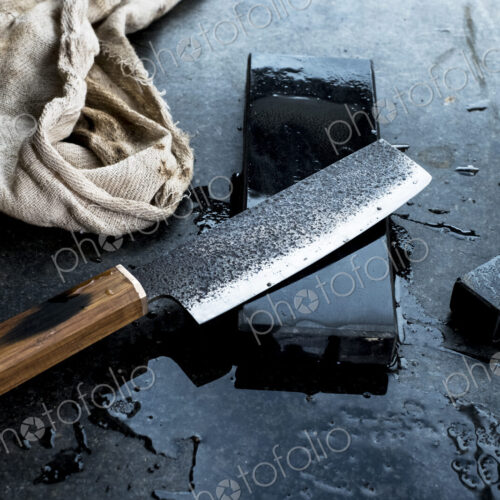 High angle close up of handmade knife on whetstone.