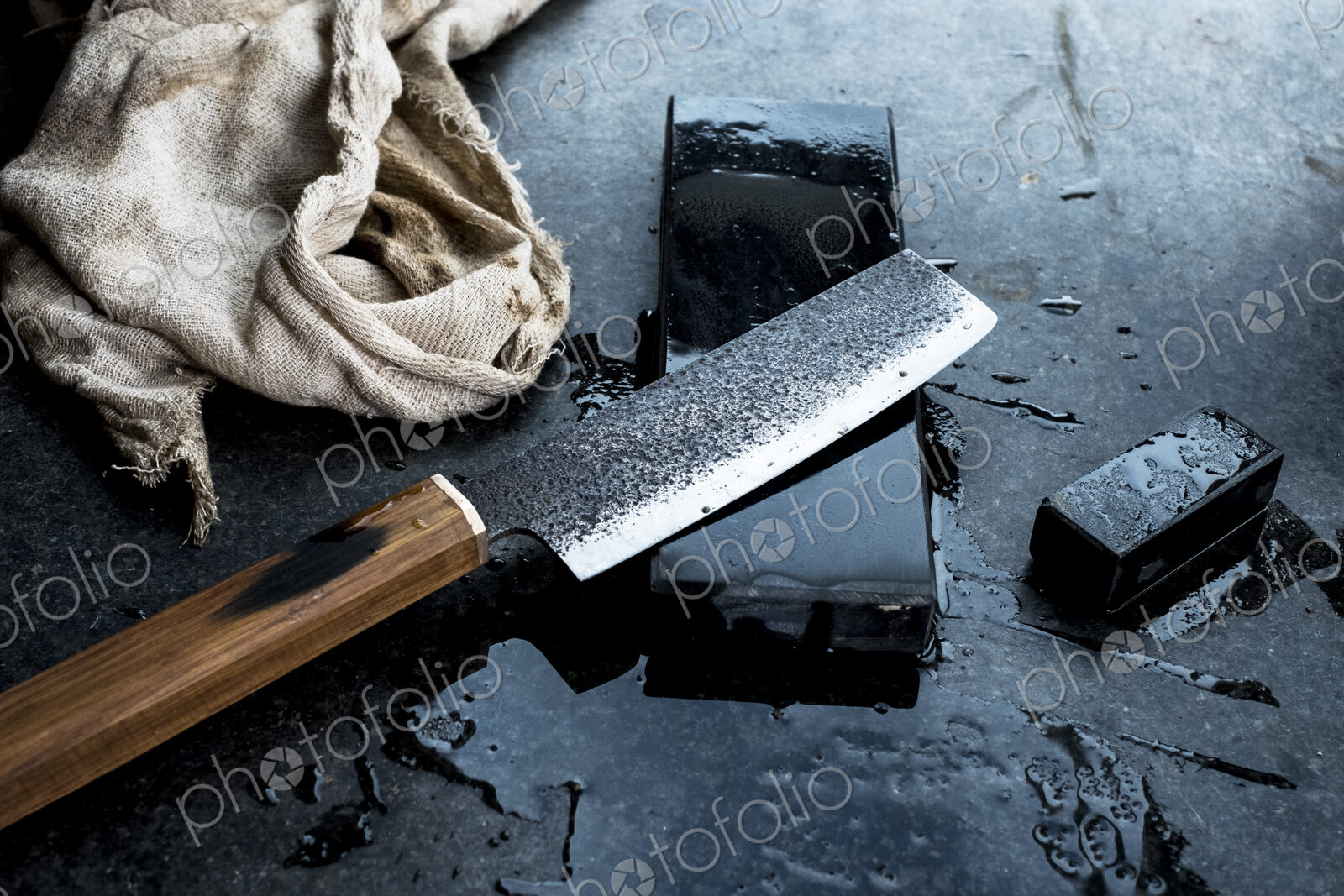 High angle close up of handmade knife on whetstone.