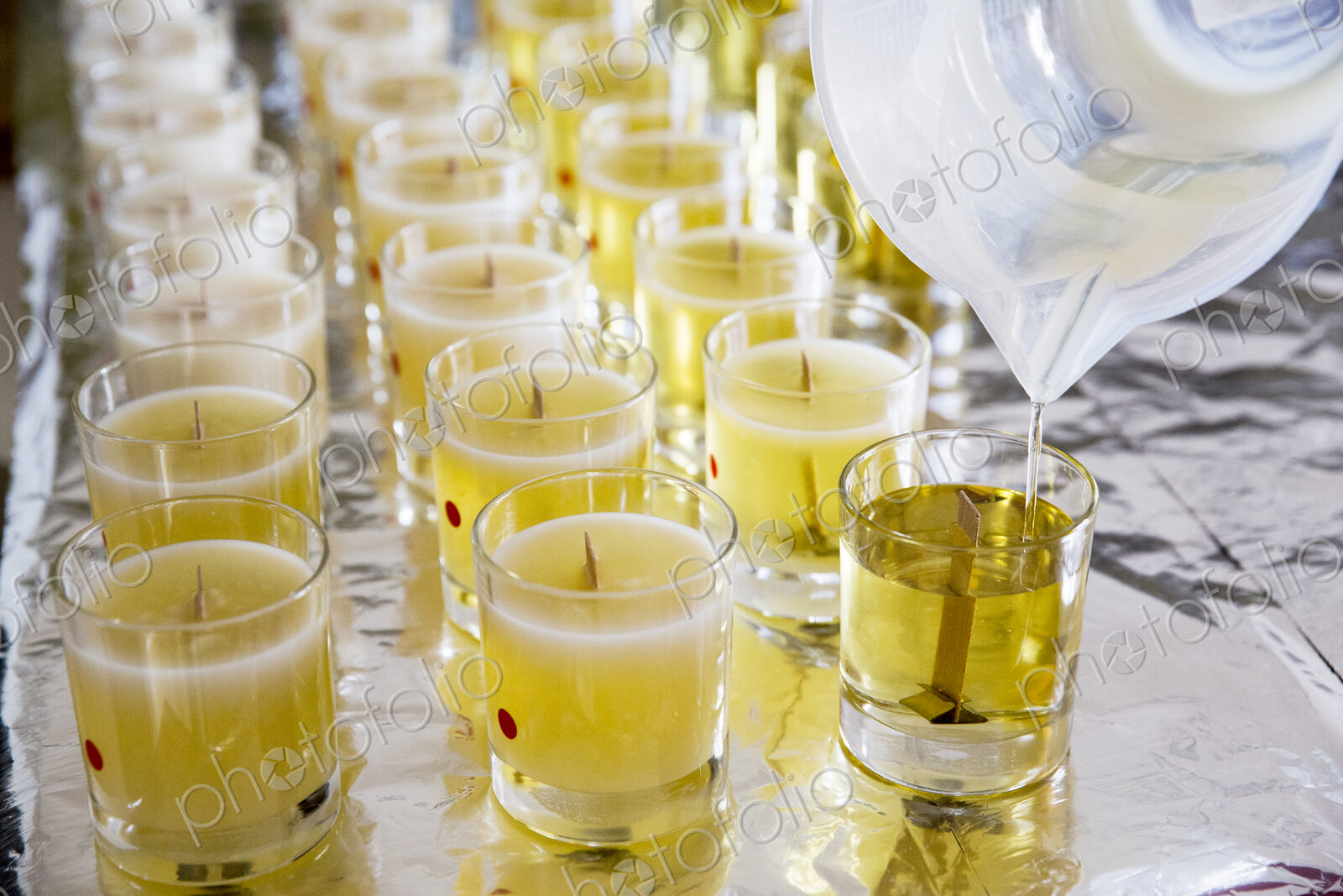 High angle close up of handmade white and yellow jar candles with wooden wick.