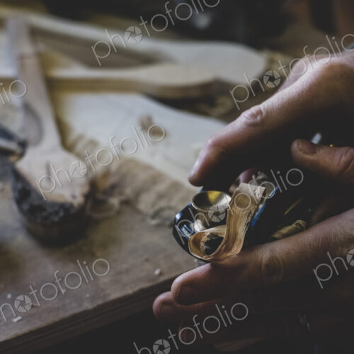High angle close up of man using plane on piece of wood. High angle close up of man using plane on piece of wood.