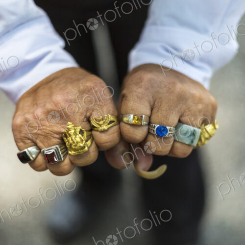 High angle close up of man wearing large ring on each finger. High angle close up of man wearing large ring on each finger.