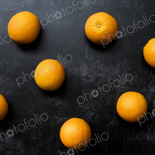 High angle close up of oranges on black background. High angle close up of oranges on black background.