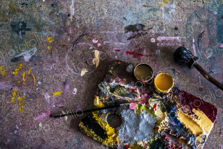 High angle close up of painter's palette and paintbrush in a workshop.
