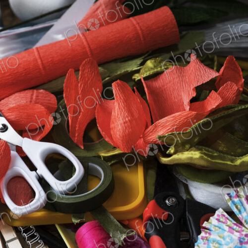 High angle close up of pair of scissors and fabric cuts in various colours.