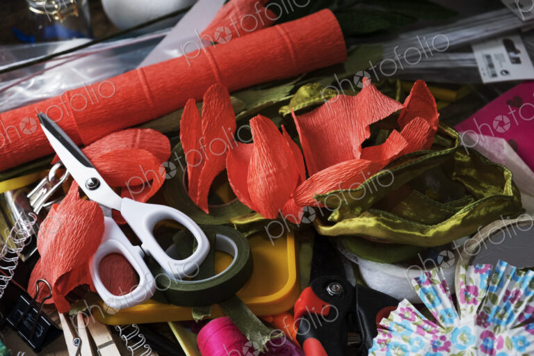 High angle close up of pair of scissors and fabric cuts in various colours.