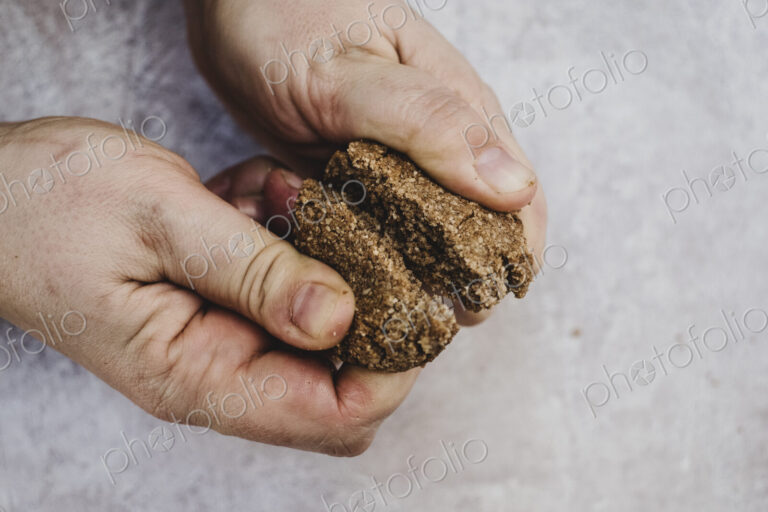 High angle close up of person breaking freshly baked chocolate cookie in half.