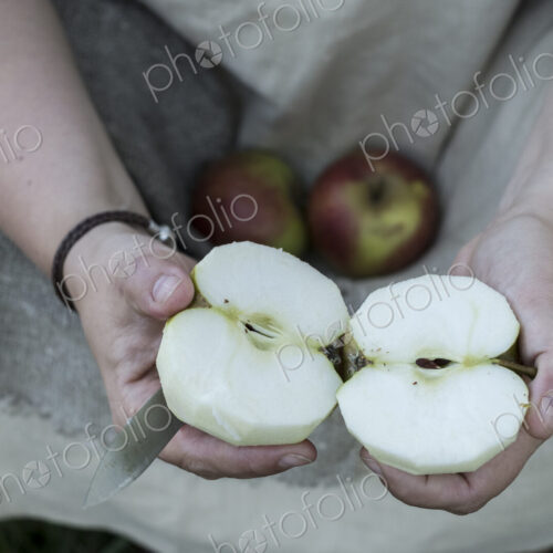 High angle close up of person holding apple cut in half. High angle close up of person holding apple cut in half.