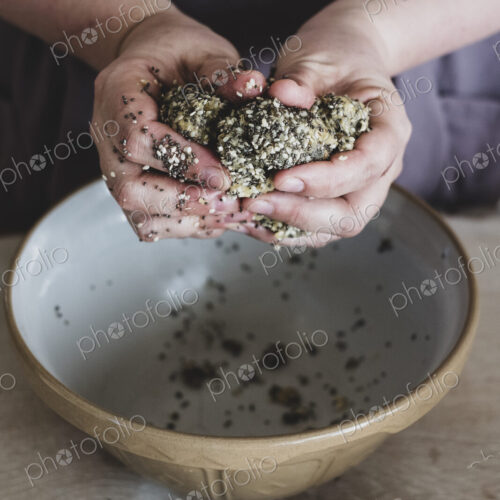 High angle close up of person kneading dough over mixing bowl.
