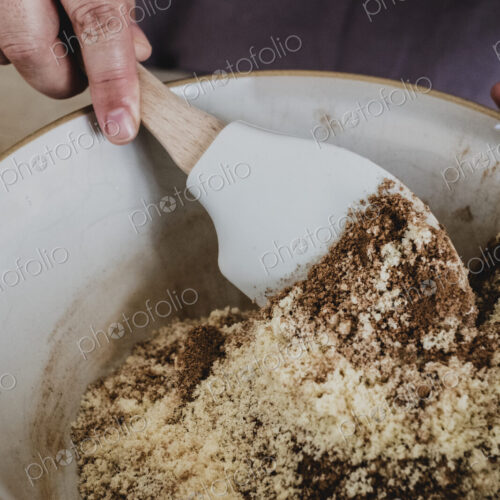 High angle close up of person mixing baking ingredients using spatula.