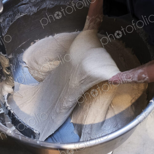 High angle close up of person preparing sourdough in an industrial mixer in an artisan…