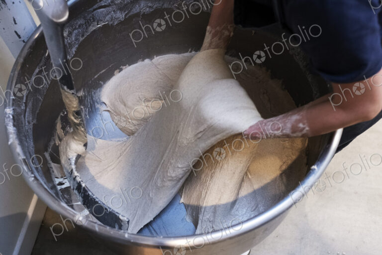High angle close up of person preparing sourdough in an industrial mixer in an artisan…