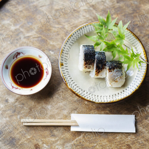 High angle close up of plate of Sushi and bowl of Soy Sauce on a table in Japanese… High angle close up of plate of Sushi and bowl of Soy Sauce on a table in Japanese…