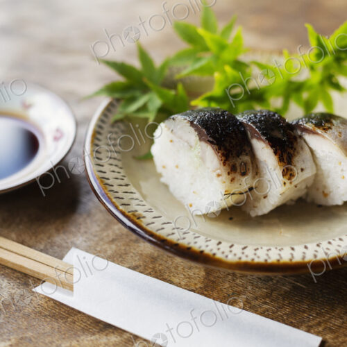 High angle close up of plate of Sushi and bowl of Soy Sauce on a table in Japanese… High angle close up of plate of Sushi and bowl of Soy Sauce on a table in Japanese…