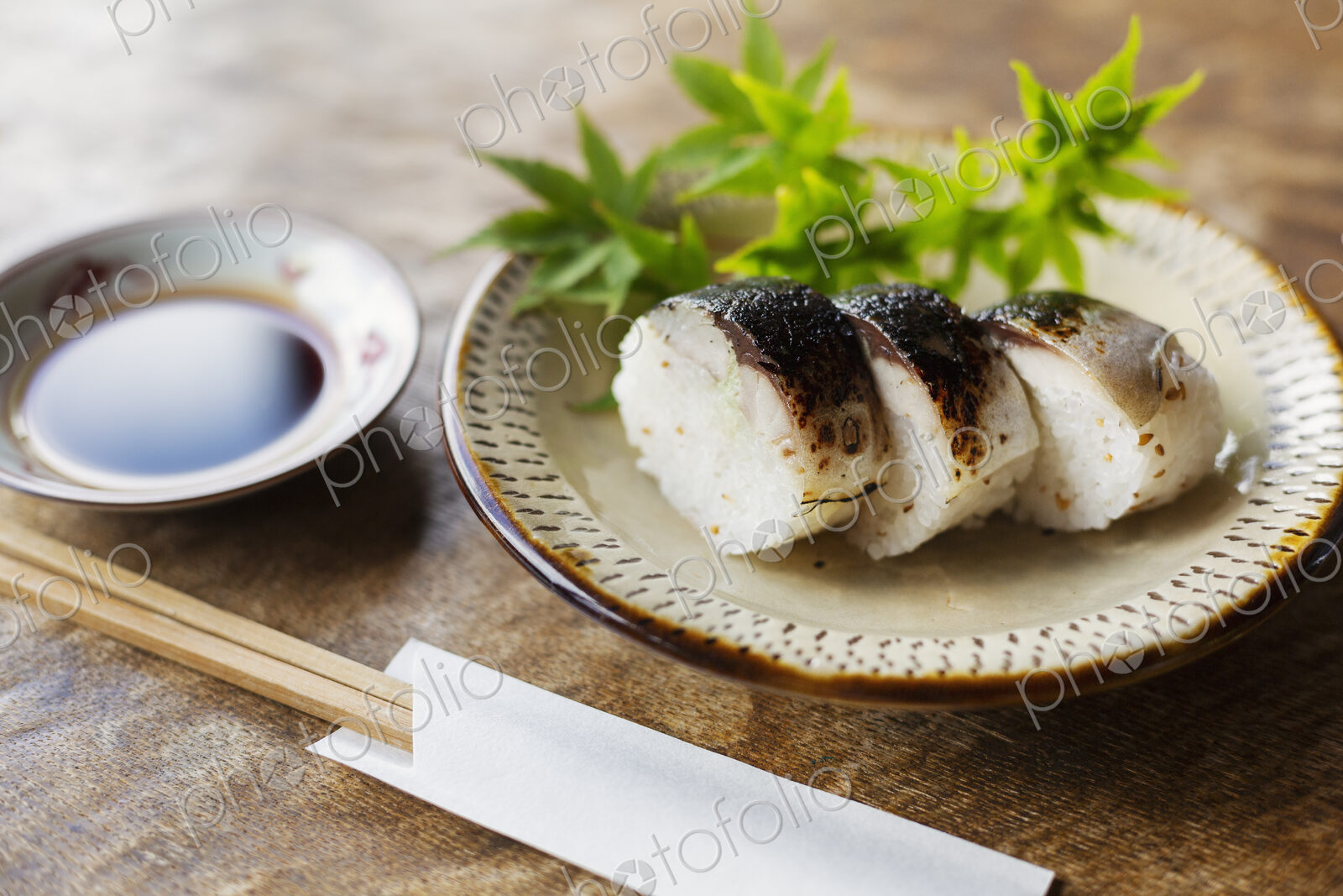 High angle close up of plate of Sushi and bowl of Soy Sauce on a table in Japanese…