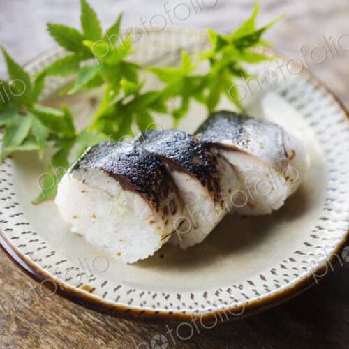 High angle close up of plate of Sushi and bowl of Soy Sauce on a table in Japanese… High angle close up of plate of Sushi and bowl of Soy Sauce on a table in Japanese…