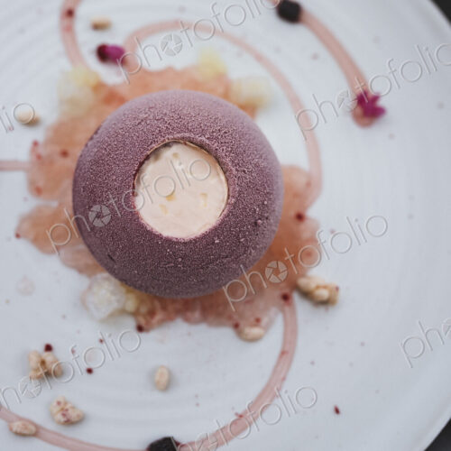 High angle close up of plate of dessert with with a cassis bombe and elderflower… High angle close up of plate of dessert with with a cassis bombe and elderflower…