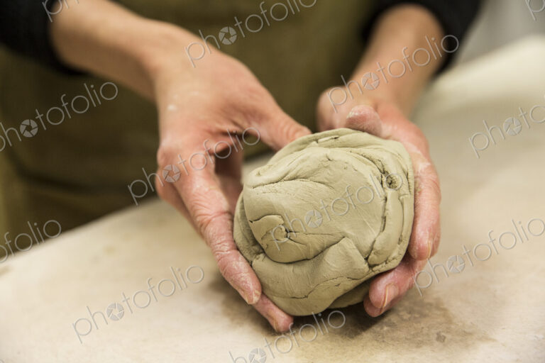 High angle close up of potter kneading piece of pottery clay.