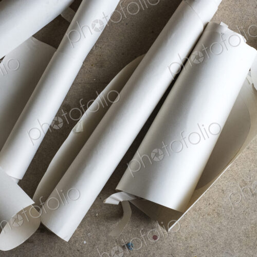 High angle close up of rolls and cut-offs of pieces of drawing paper. High angle close up of rolls and cut-offs of pieces of drawing paper.