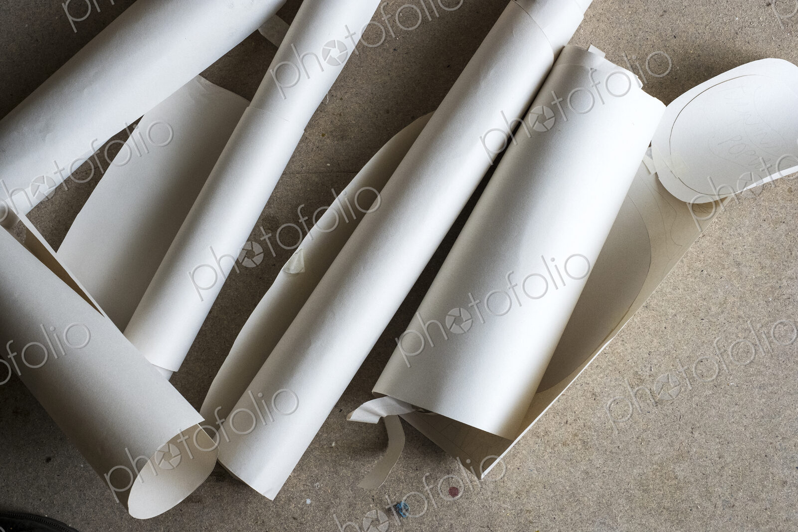 High angle close up of rolls and cut-offs of pieces of drawing paper.