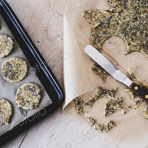 High angle close up of seeded cracker dough on a baking tray. High angle close up of seeded cracker dough on a baking tray.