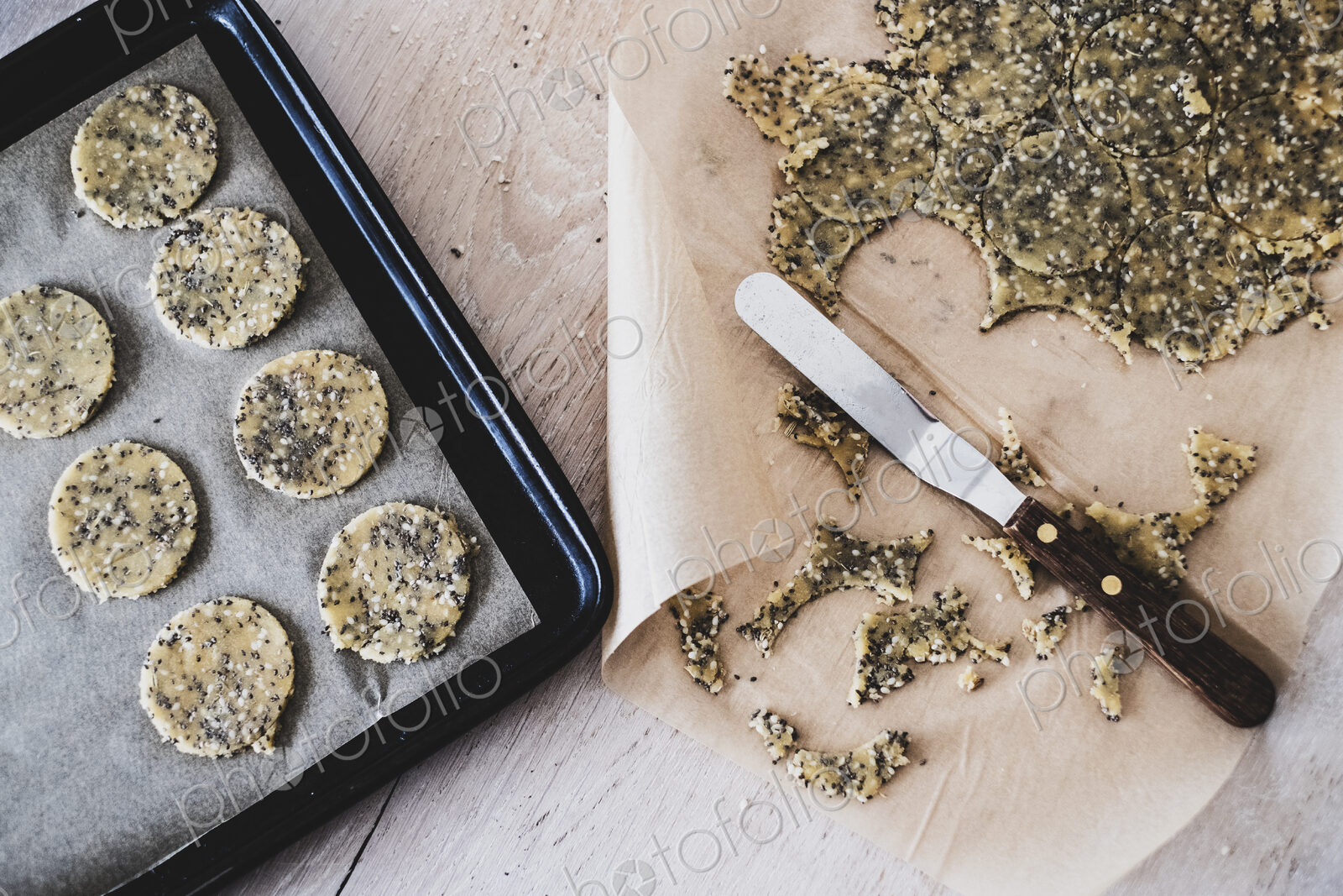 High angle close up of seeded cracker dough on a baking tray.